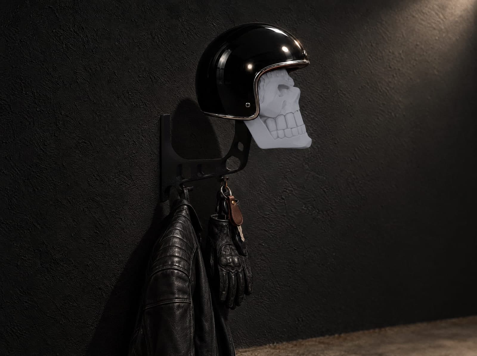 A glossy black helmet on a Ghost Grey skull mount, with a jacket, gloves and keys on its hooks, clear of the floor